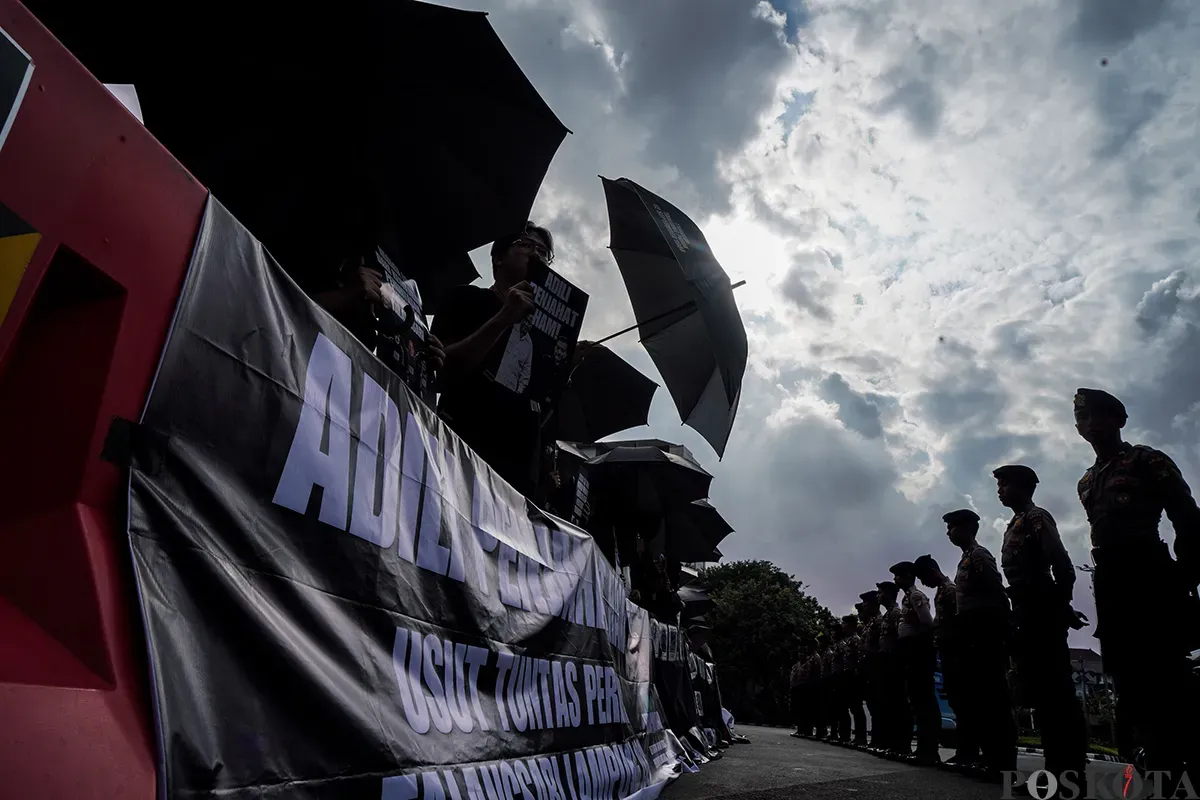 Sejumlah aktivis menggunakan baju hitam sambil membawa payung dan poster kejadian, mengikuti Aksi Kamisan Peringatan 36 Tahun Peristiwa Talangsari Lampung, di depan Istana Merdeka, Jakarta, Kamis, 7 Februari 2025. (Sumber: Poskota/Bilal Nugraha Ginanjar)