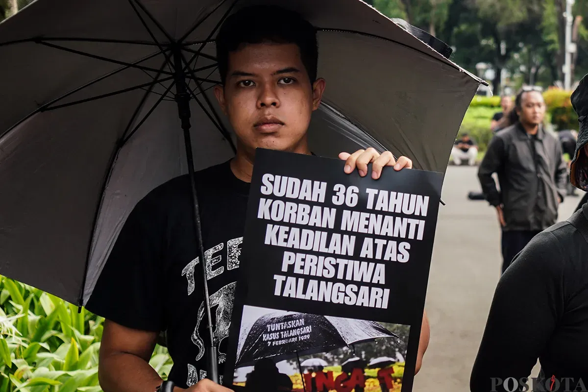 Sejumlah aktivis menggunakan baju hitam sambil membawa payung dan poster kejadian, mengikuti Aksi Kamisan Peringatan 36 Tahun Peristiwa Talangsari Lampung, di depan Istana Merdeka, Jakarta, Kamis, 7 Februari 2025. (Sumber: Poskota/Bilal Nugraha Ginanjar)