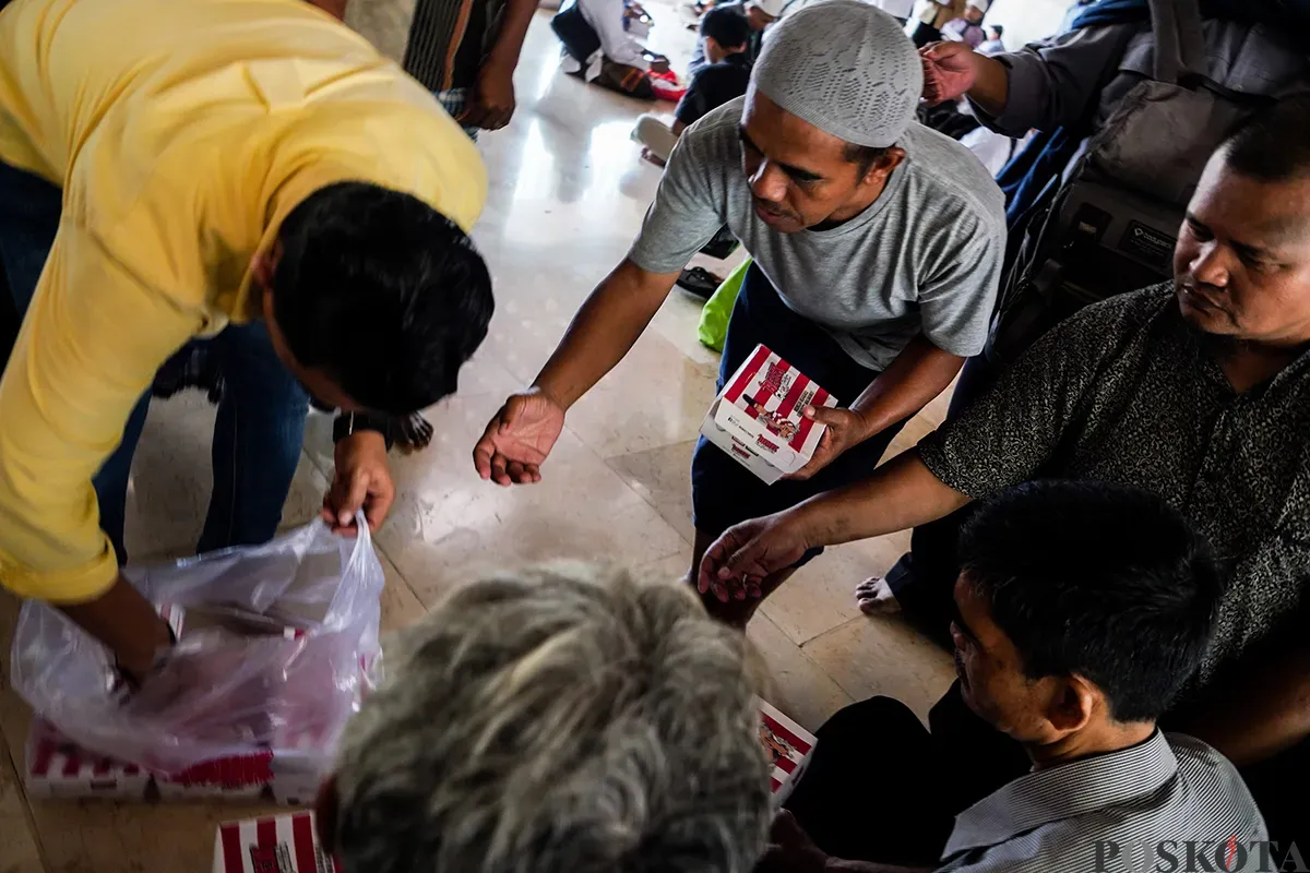 Petugas membagikan makanan berupa nasi box secara gratis kepada sejumlah warga seusai melaksanakan ibadah shalat Jumat di Masjid Istiqlal, Jakarta, Jumat, 7 Februari 2025. (Sumber: Poskota/Bilal Nugraha Ginanjar)