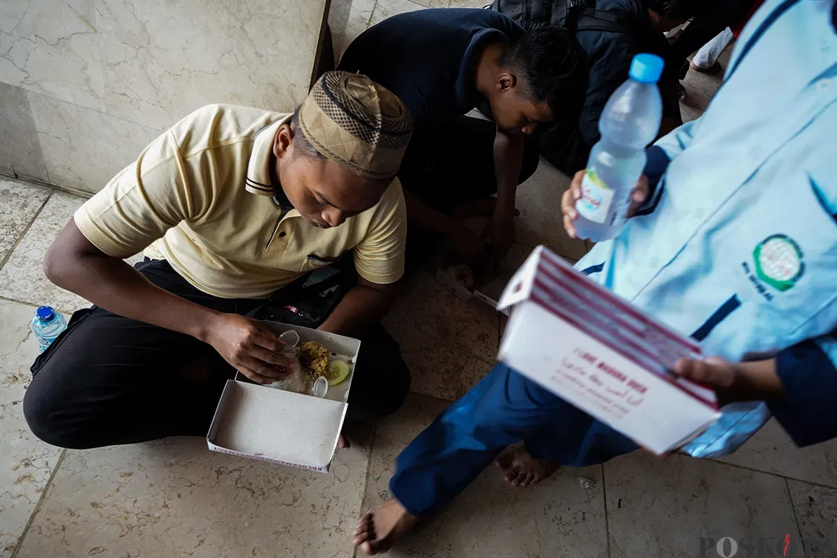 Petugas membagikan makanan berupa nasi box secara gratis kepada sejumlah warga seusai melaksanakan ibadah shalat Jumat di Masjid Istiqlal, Jakarta, Jumat, 7 Februari 2025. (Sumber: Poskota/Bilal Nugraha Ginanjar)