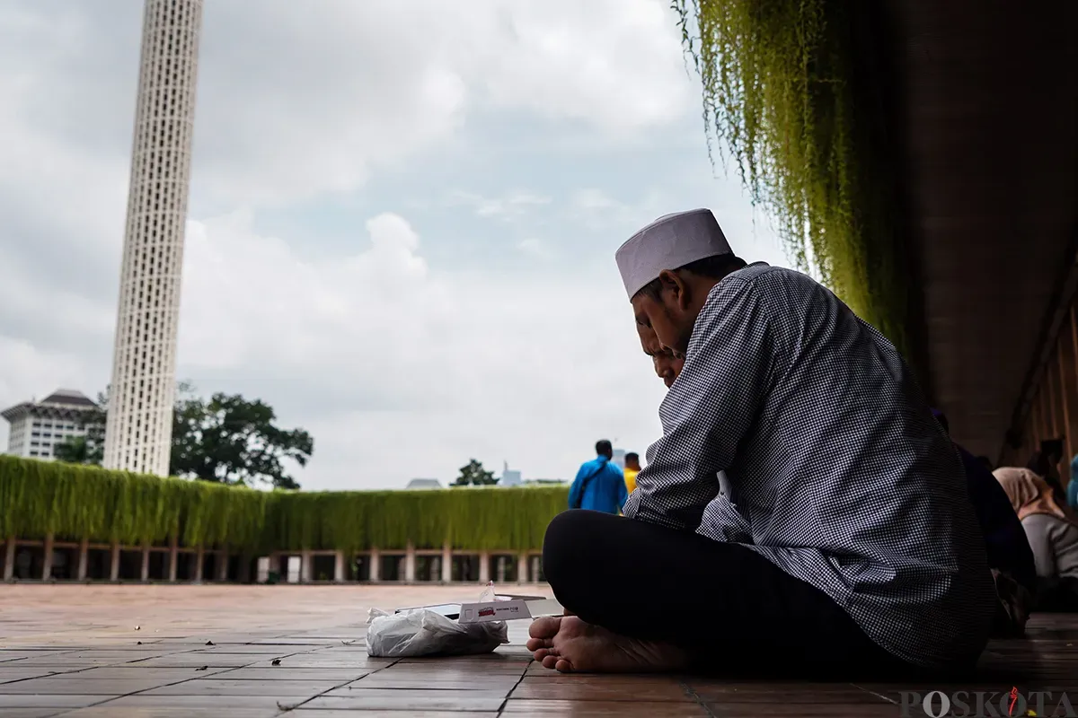 Petugas membagikan makanan berupa nasi box secara gratis kepada sejumlah warga seusai melaksanakan ibadah shalat Jumat di Masjid Istiqlal, Jakarta, Jumat, 7 Februari 2025. (Sumber: Poskota/Bilal Nugraha Ginanjar)