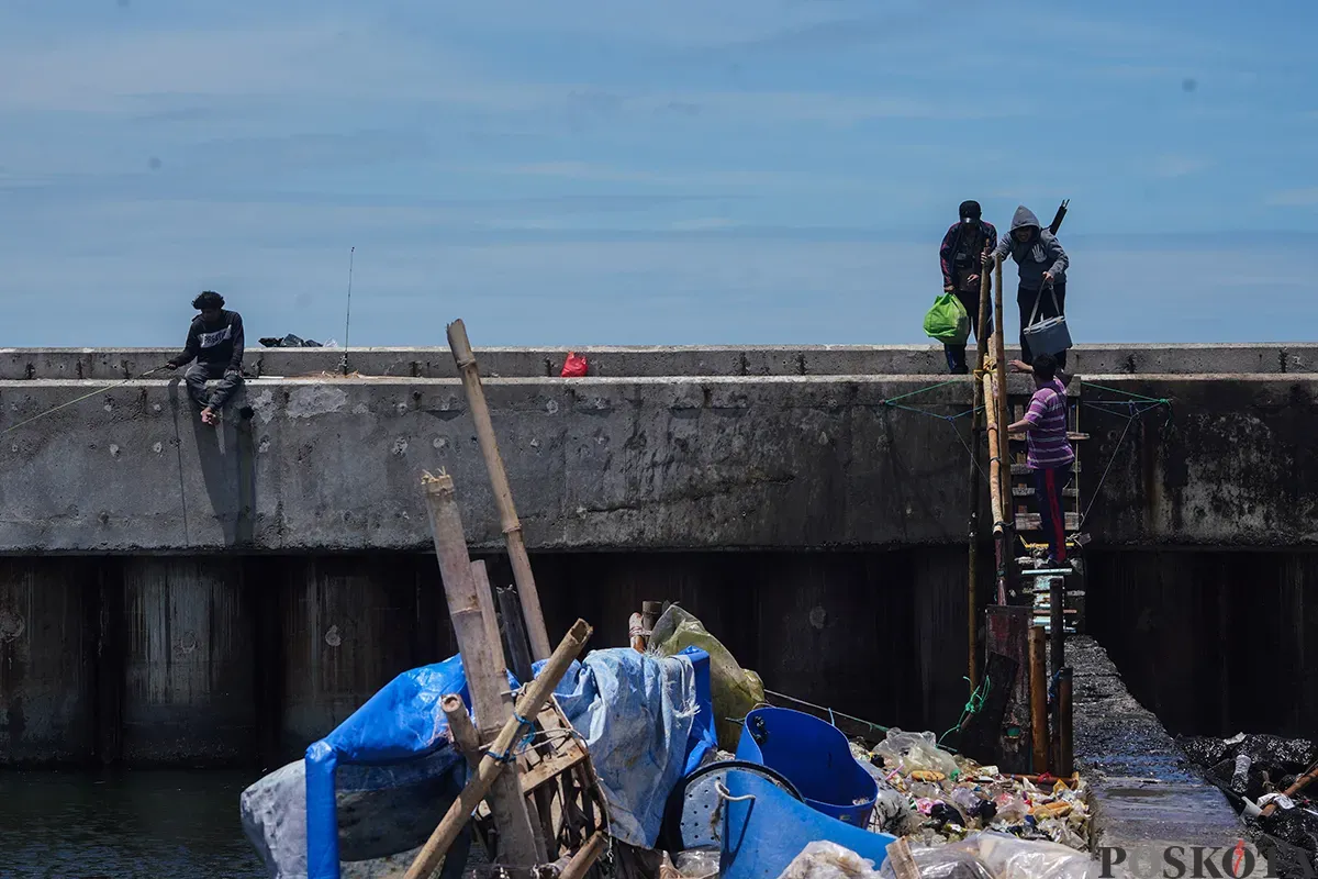 Sejumlah warga memancing ikan laut dari atas tanggul Muara Baru, Penjarjngan, Jakarta Utara, Rabu, 5 Februari 2025. (Sumber: Poskota/Bilal Nugraha Ginanjar)