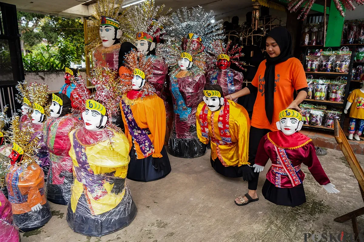 Pengrajin memotong kayu rangka boneka khas betawi 'Ondel-ondel' sekaligus memasarkannya melalui galeri Betawi Online Gallery di Setu Babakan, Jakarta Selatan, Senin, 10 Februari 2025. (Sumber: Poskoata/ Bilal Nugraha Ginanjar)