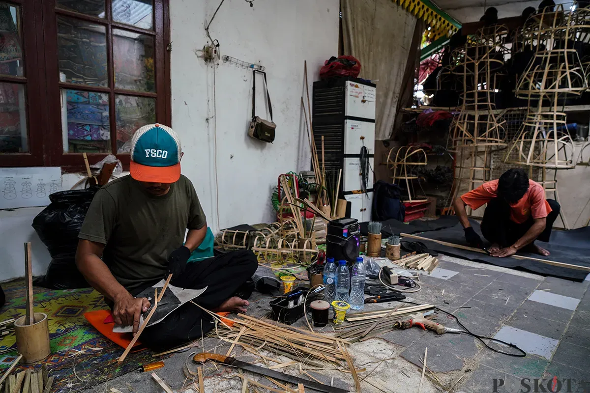 Pengrajin memotong kayu rangka boneka khas betawi 'Ondel-ondel' sekaligus memasarkannya melalui galeri Betawi Online Gallery di Setu Babakan, Jakarta Selatan, Senin, 10 Februari 2025. (Sumber: Poskoata/ Bilal Nugraha Ginanjar)