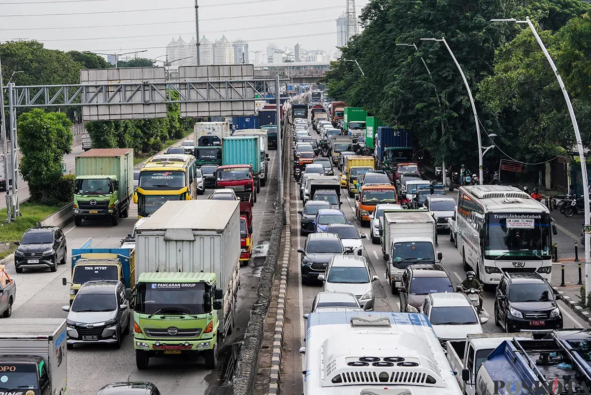 Polisi lalu lintas mengatur laju kendaraan yang melintas di kawasan Gerbang Tol Kebon Bawang, Koja, Jakarta Utara, Selasa, 11 Februari 2025. (Sumber: Poskoata/ Bilal Nugraha Ginanjar)