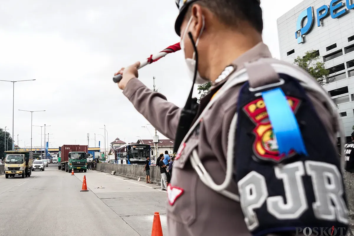 Polisi lalu lintas mengatur laju kendaraan yang melintas di kawasan Gerbang Tol Kebon Bawang, Koja, Jakarta Utara, Selasa, 11 Februari 2025. (Sumber: Poskoata/ Bilal Nugraha Ginanjar)