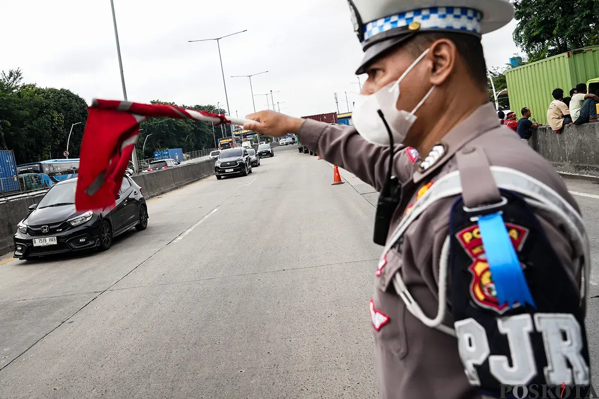 Polisi lalu lintas mengatur laju kendaraan yang melintas di kawasan Gerbang Tol Kebon Bawang, Koja, Jakarta Utara, Selasa, 11 Februari 2025. (Sumber: Poskoata/ Bilal Nugraha Ginanjar)