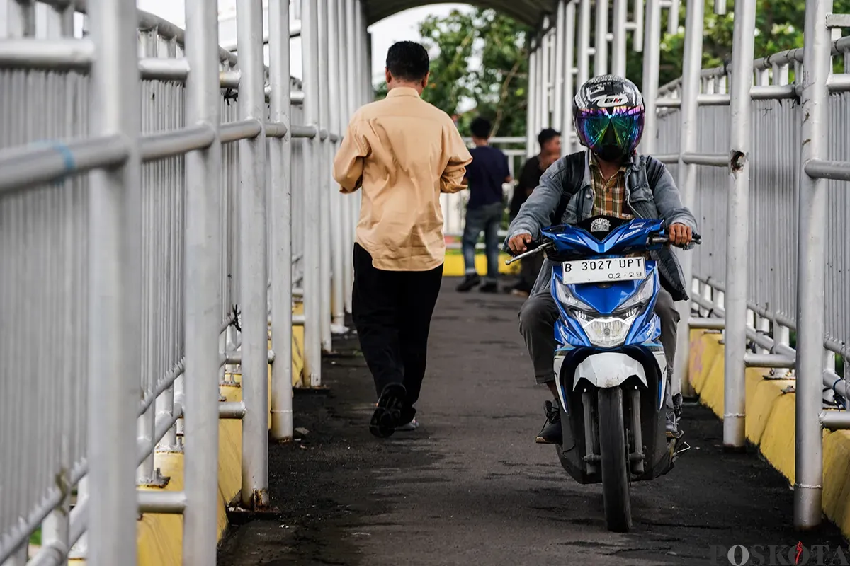 Pengendara sepeda motor melintas di Jembatan Penyebrangan Orang (JPO), di Jalan Yos Sudarso, Koja, Jakarta Utara, Selasa, 11 Februari 2025. (Sumber: Poskoata/ Bilal Nugraha Ginanjar)