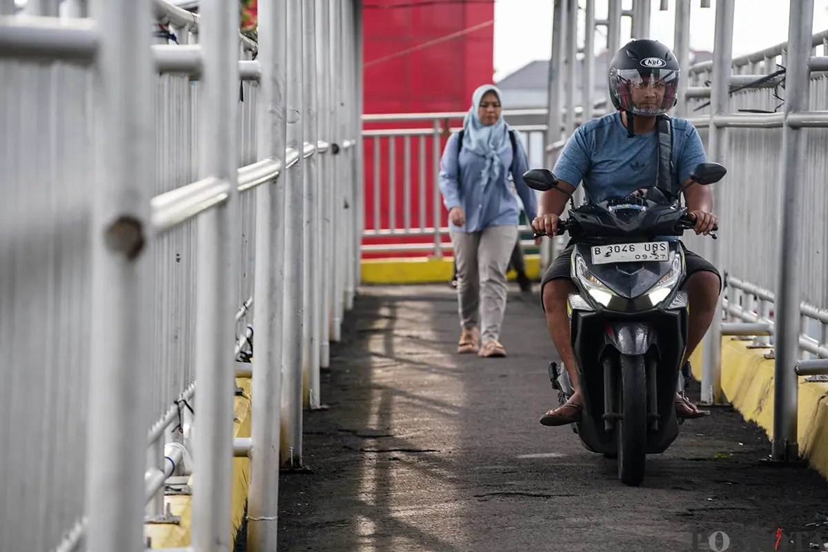 Pengendara sepeda motor melintas di Jembatan Penyebrangan Orang (JPO), di Jalan Yos Sudarso, Koja, Jakarta Utara, Selasa, 11 Februari 2025. (Sumber: Poskoata/ Bilal Nugraha Ginanjar)