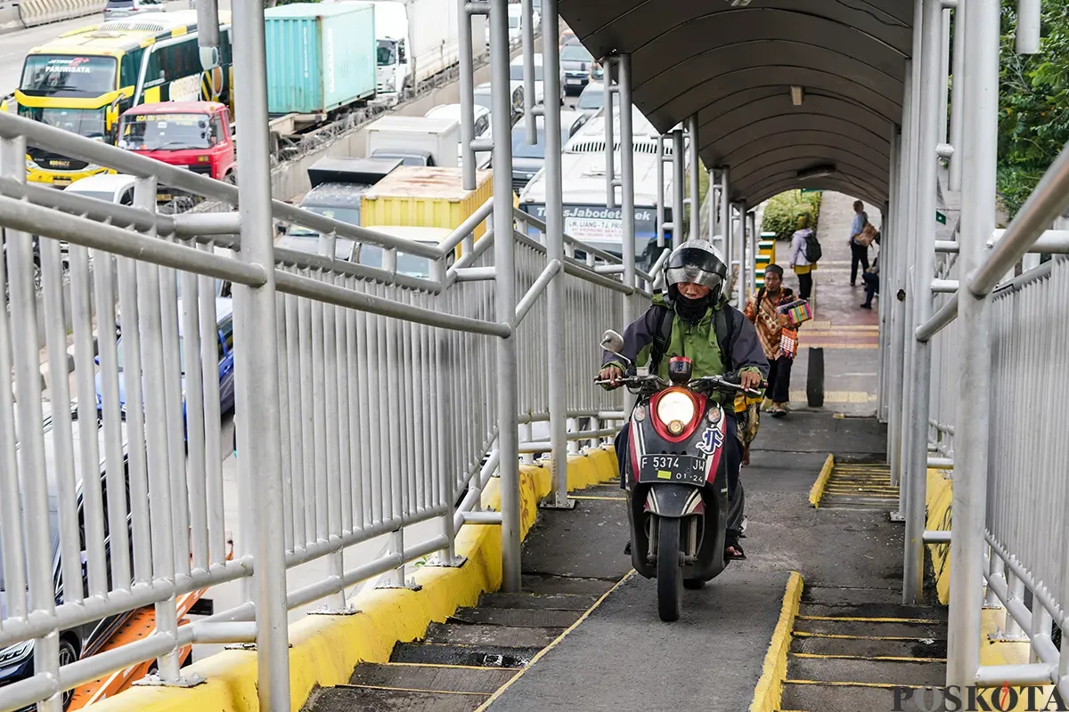 Pengendara sepeda motor melintas di Jembatan Penyebrangan Orang (JPO), di Jalan Yos Sudarso, Koja, Jakarta Utara, Selasa, 11 Februari 2025. (Sumber: Poskoata/ Bilal Nugraha Ginanjar)