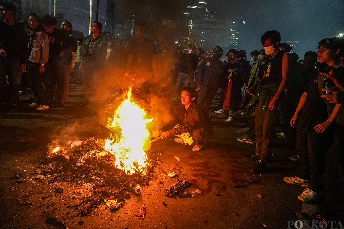 Mahasiswa yang tergabung dalam Badan Eksekutif Mahasiswa Seluruh Indonesia (BEM-SI) membakar spanduk dan ban bekas saat melakukan aksi unjuk rasa di sekitar Patung Arjuna Wijaya, Jakarta, Senin, 17 Februari 2025. (Sumber: Poskota/Bilal Nugraha Ginanjar)