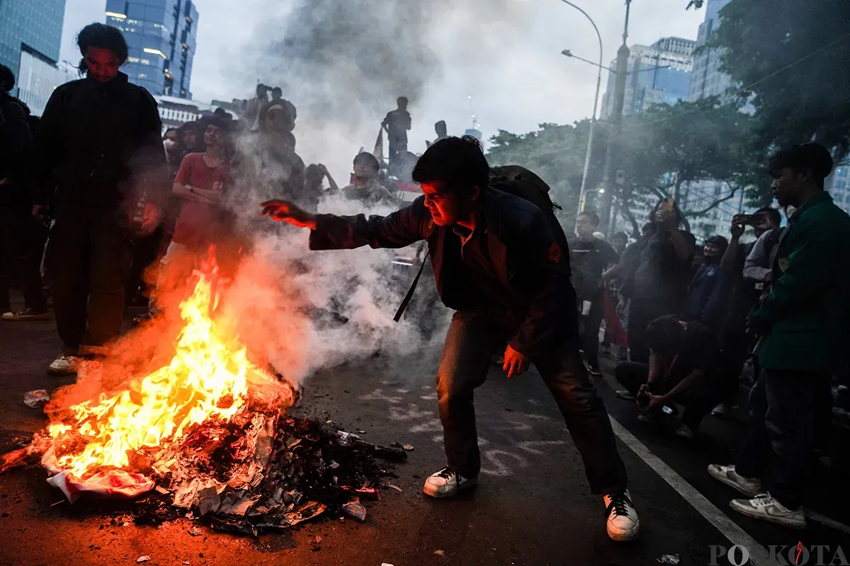 Mahasiswa yang tergabung dalam Badan Eksekutif Mahasiswa Seluruh Indonesia (BEM-SI) membakar spanduk dan ban bekas saat melakukan aksi unjuk rasa di sekitar Patung Arjuna Wijaya, Jakarta, Senin, 17 Februari 2025. (Sumber: Poskota/Bilal Nugraha Ginanjar)