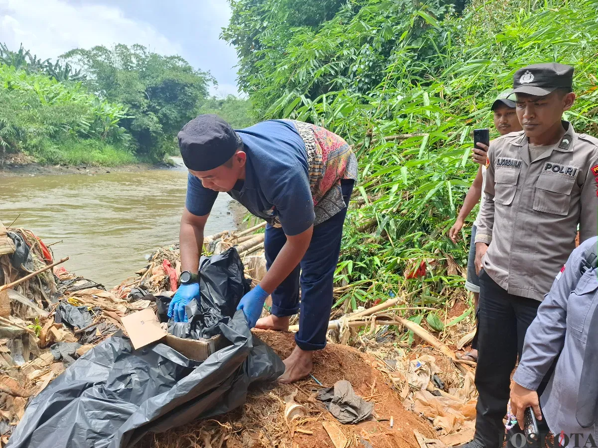 Petugas mengevakuasi jasad bayi laki-laki tersangkut bambu di Kali Ciliwung, Bojonggede, Kabupaten Bogor, Rabu, 19 Februari 2025. (Sumber: Poskota/Angga Pahlevi)