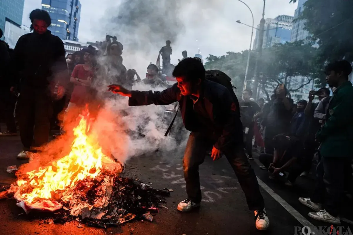 Mahasiswa yang tergabung dalam Badan Eksekutif Mahasiswa Seluruh Indonesia (BEM-SI) membakar spanduk dan ban bekas saat melakukan aksi unjuk rasa di sekitar Patung Arjuna Wijaya, Jakarta, 17 Februari 2025. (Sumber: Poskota/Bilal Nugraha Ginanjar)