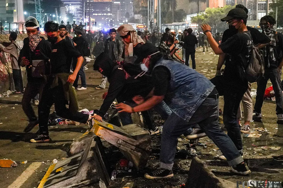 Massa aksi mulai melemparkan benda tumpul seperti batu dan menembakan kembang api ke arah polisi yang berjaga pada aksi unjuk rasa di sekitar Patung Arjuna Wijaya, Jakarta, 21 Februari 2025. (Sumber: Poskota/Bilal Nugraha Ginanjar)