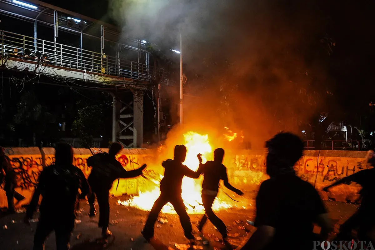 Massa aksi mulai melemparkan benda tumpul seperti batu dan menembakan kembang api ke arah polisi yang berjaga pada aksi unjuk rasa di sekitar Patung Arjuna Wijaya, Jakarta, 21 Februari 2025. (Sumber: Poskota/Bilal Nugraha Ginanjar)