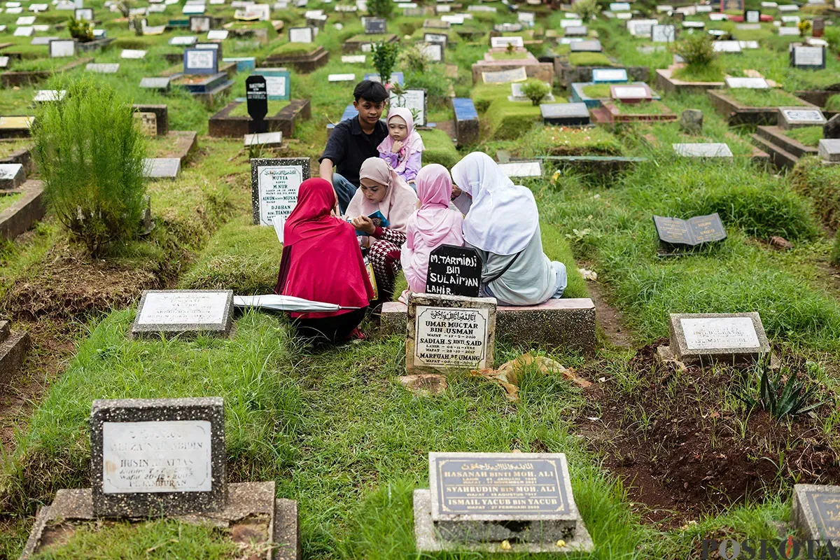 Sejumlah keluarga memanjatkan doa di depan makam anggota keluarganya saat melakukan ziarah kubur di Taman Pemakaman Umum (TPU) Karet, Tanah Abang, Jakarta, Sabtu, 22 Februari 2025. (Sumber: Poskota/Bilal Nugraha Ginanjar)