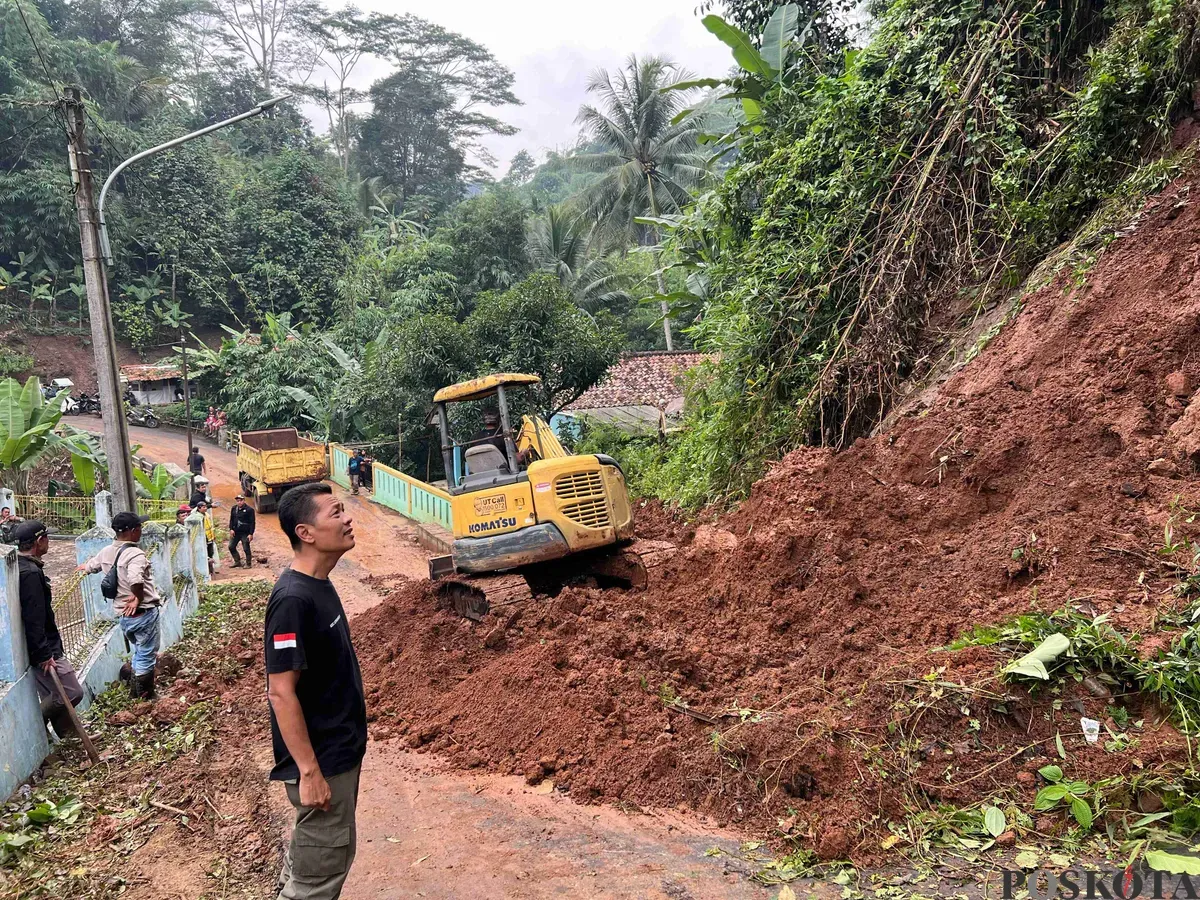 Petugas BPBD KBB dan warga berjibaku membersihkan material longsor di Jalan Raya Kampung Tugu RW 14 Desa Ciharashas, Kecamatan Cipeundeuy, Rabu 26 Februari 2025. (Sumber: Poskota/Gatot Poedji Utomo)