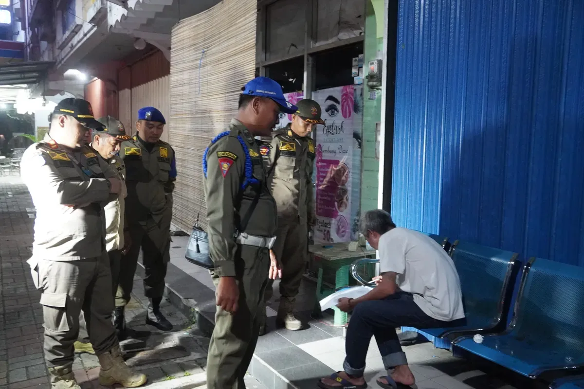 Petugas Satpol PP saat memberikan surat edaran tentang jam operasional usaha di Kabupaten Tangerang selama bulan Ramadhan. (Sumber: Poskota/Veronica Prasetio)