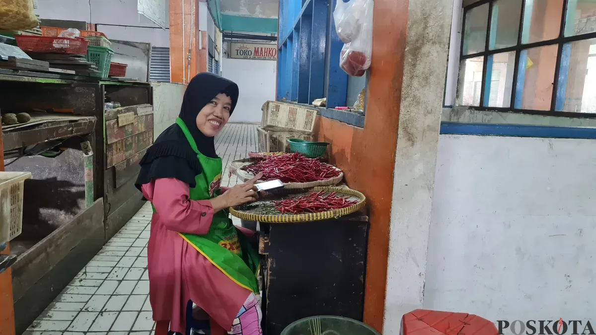 Sri, pedagang sayur mayur di Pasar Slipi, Jakarta Barat, saat tengah memilah cabai, Kamis, 2 Januari 2025. (Sumber: Poskota/Pandi)