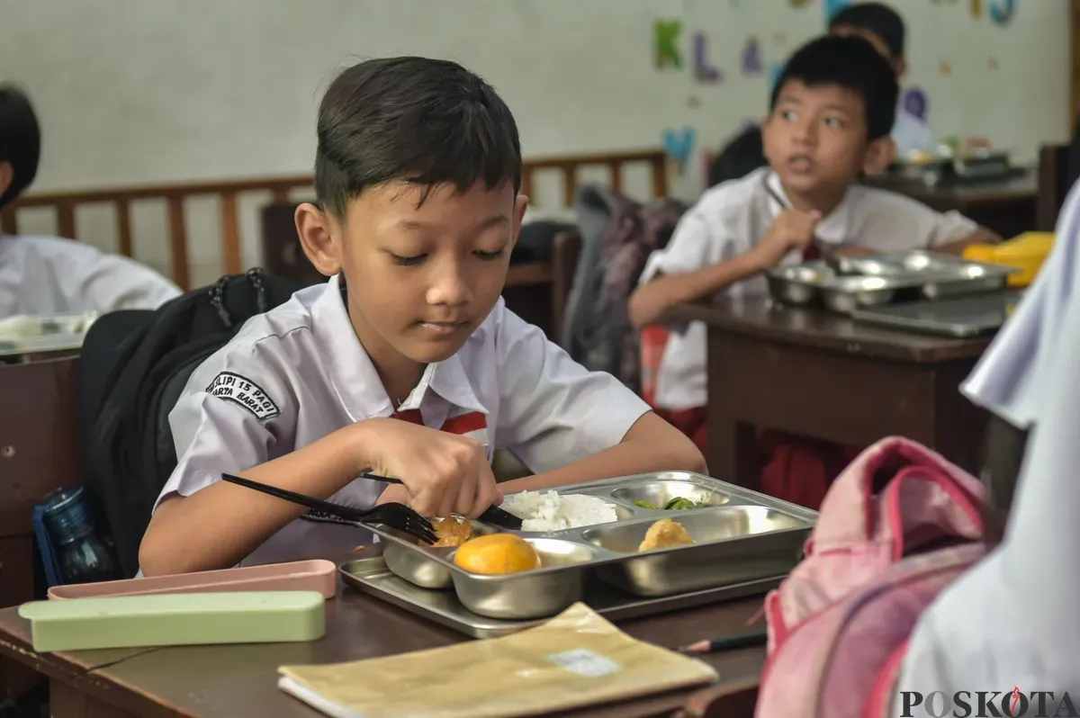 Sejumlah siswa menyantap menu makan siang dari program Makan Bergizi Gratis (MBG) Nasional di ruang kelas SDN Slipi 15, Jakarta Barat, Senin, 6 Januari 2025. (Sumber: Poskoata/ Bilal Nugraha Ginanjar)