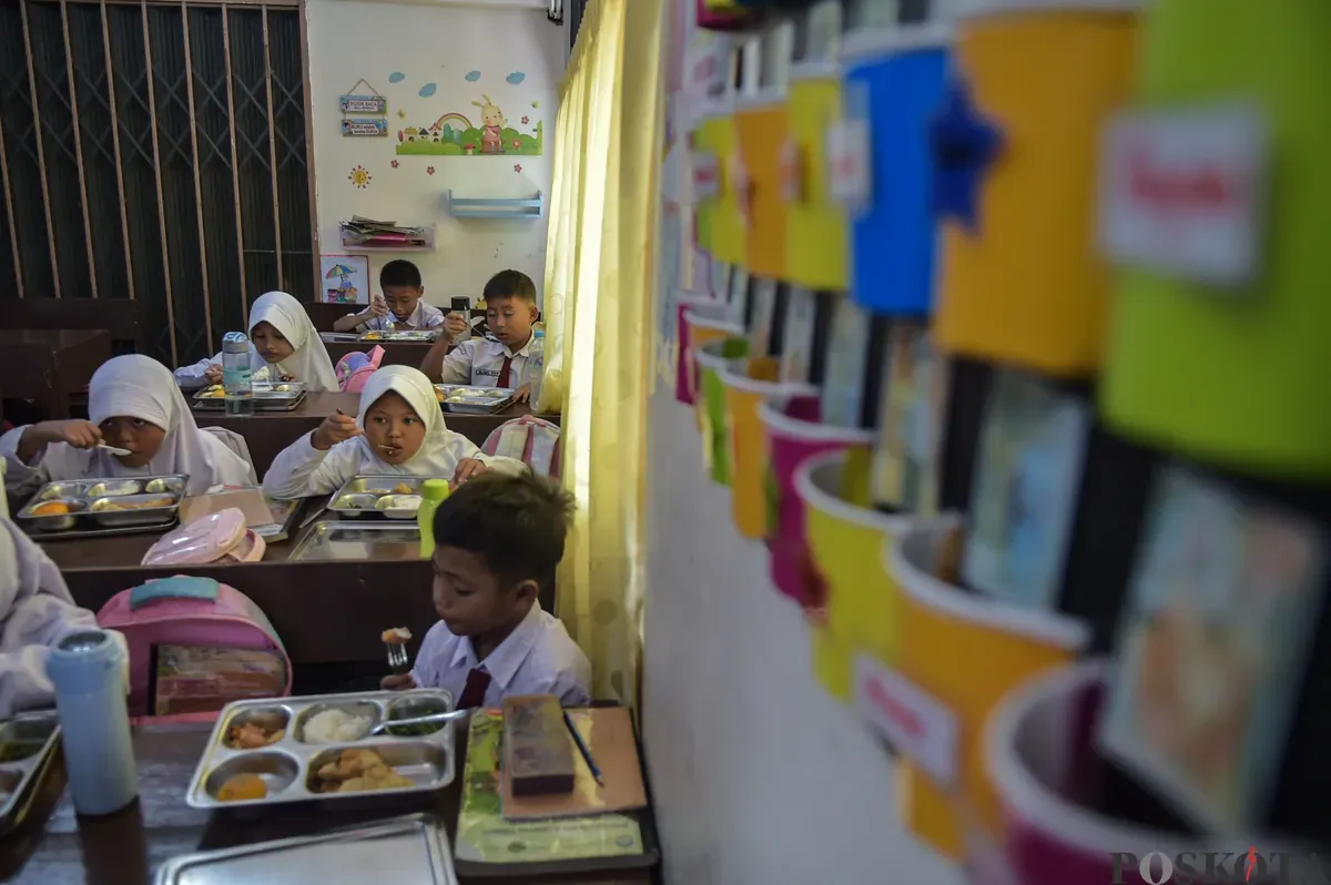 Sejumlah siswa menyantap menu makan siang dari program Makan Bergizi Gratis (MBG) Nasional di ruang kelas SDN Slipi 15, Jakarta Barat, Senin, 6 Januari 2025. (Sumber: Poskoata/ Bilal Nugraha Ginanjar)