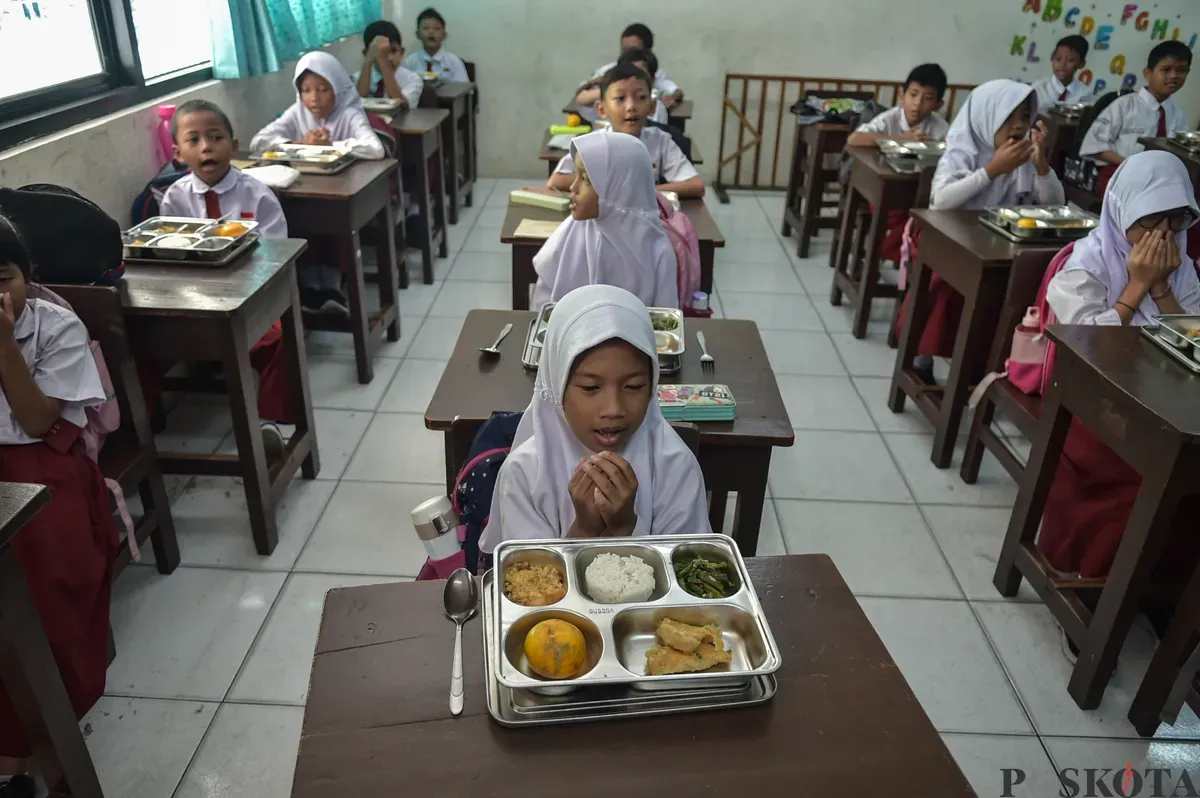 Sejumlah siswa menyantap menu makan siang dari program Makan Bergizi Gratis (MBG) Nasional di ruang kelas SDN Slipi 15, Jakarta Barat, Senin, 6 Januari 2025. (Sumber: Poskoata/ Bilal Nugraha Ginanjar)