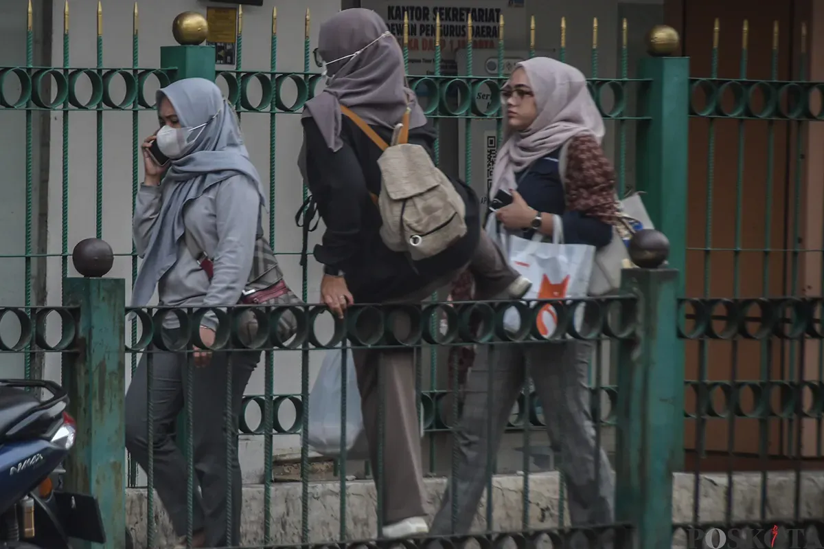 Sejumlah calon penumpang kereta api melompati pagar pembatas jalan raya dengan jalur pejalan kaki di kawasan Stasiun Cikini, Jakarta Pusat, Selasa, 7 Januari 2025.  (Poskota/ Bilal Nugraha Ginanjar) (Sumber: Poskoata/ Bilal Nugraha Ginanjar)