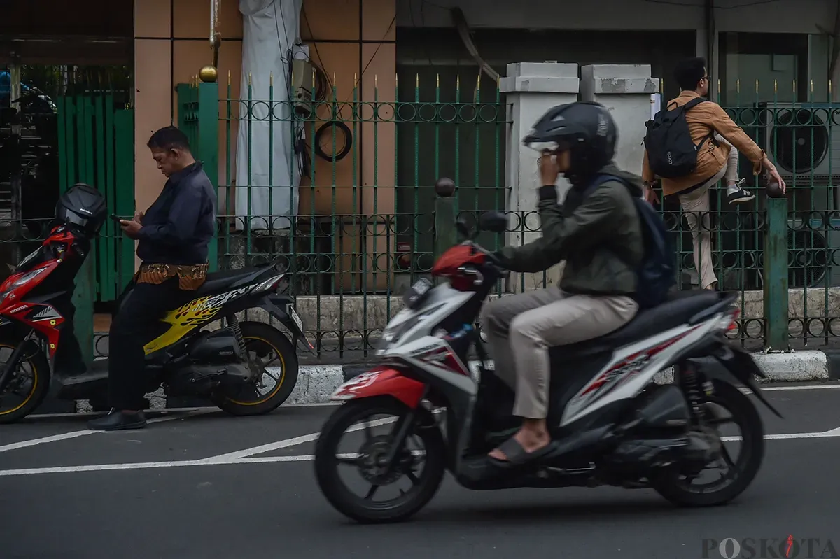 Sejumlah calon penumpang kereta api melompati pagar pembatas jalan raya dengan jalur pejalan kaki di kawasan Stasiun Cikini, Jakarta Pusat, Selasa, 7 Januari 2025.  (Poskota/ Bilal Nugraha Ginanjar) (Sumber: Poskoata/ Bilal Nugraha Ginanjar)