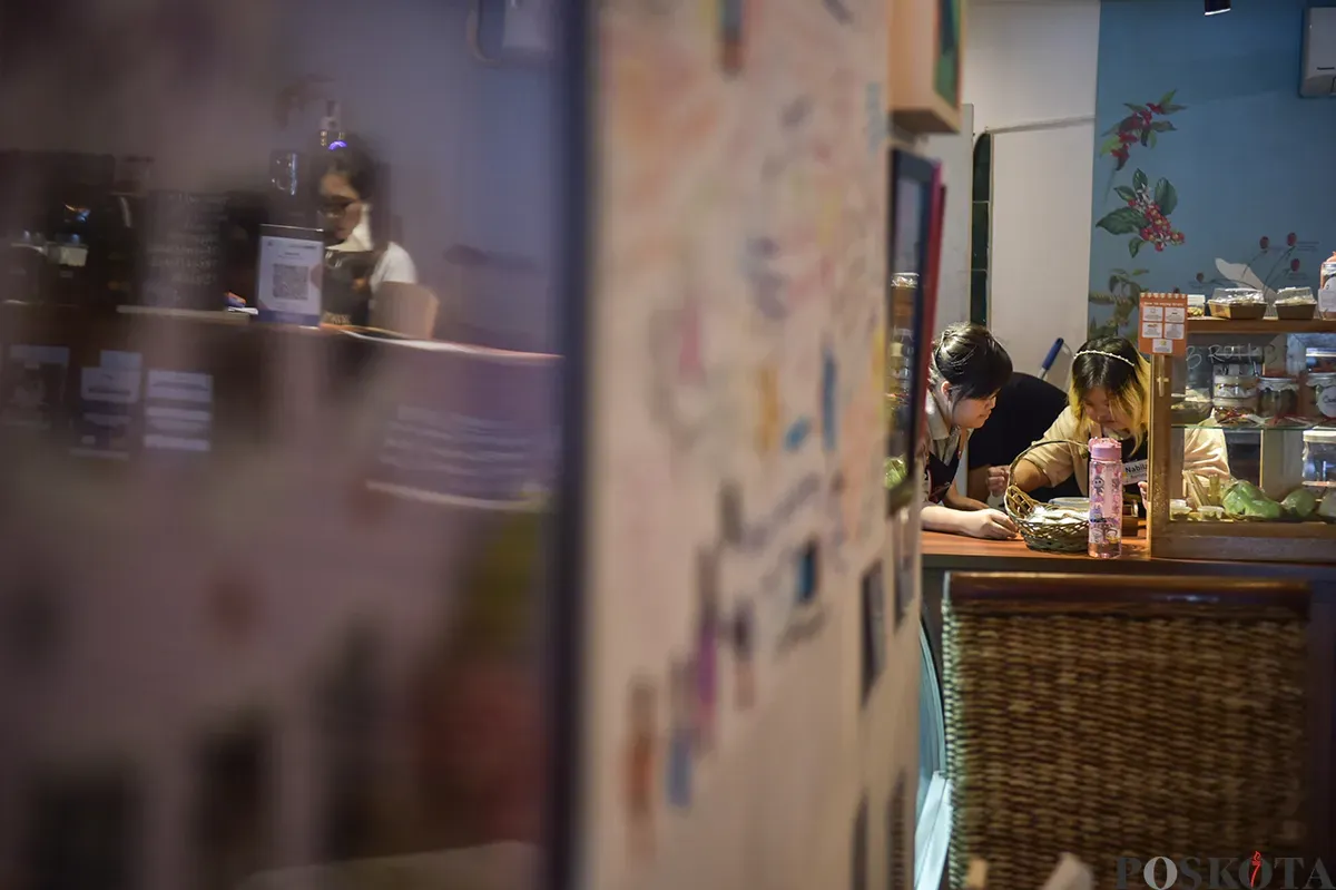 Wanita penyandang down Syndrome sekaligus berprofesi sebagai peracik kopi (Barista) ketika mengisi aktivitasnya mulai dari mempersiapkan, meracik hingga menyajikan minuman kopi pesanan pelanggannya di Kedai Kopi Kamu, Jakarta Selatan, Selasa, 7 Desember 2025. (Sumber: Poskoata/ Bilal Nugraha Ginanjar)