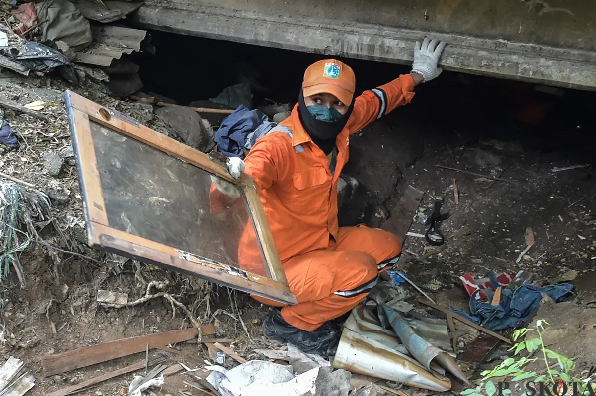 Petugas Suku Dinas Jakarta Barat, membersihkan sisa bangunan rumah bekas tempat tinggal sejumlah warga di bawah Kolong Tol Angke, Grogol Petamburan, Jakarta Barat, Selasa, 7 Januari 2025. (Sumber: Poskoata/ Bilal Nugraha Ginanjar)
