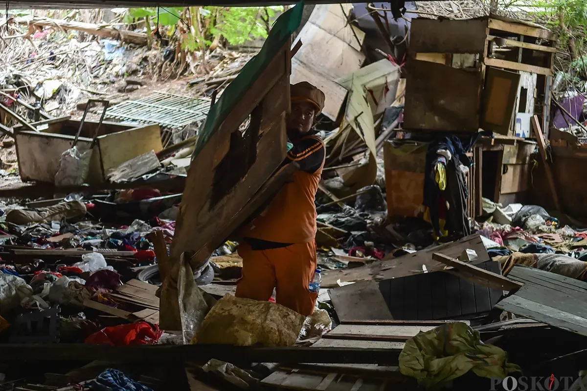 Petugas Suku Dinas Jakarta Barat, membersihkan sisa bangunan rumah bekas tempat tinggal sejumlah warga di bawah Kolong Tol Angke, Grogol Petamburan, Jakarta Barat, Selasa, 7 Januari 2025. (Sumber: Poskoata/ Bilal Nugraha Ginanjar)