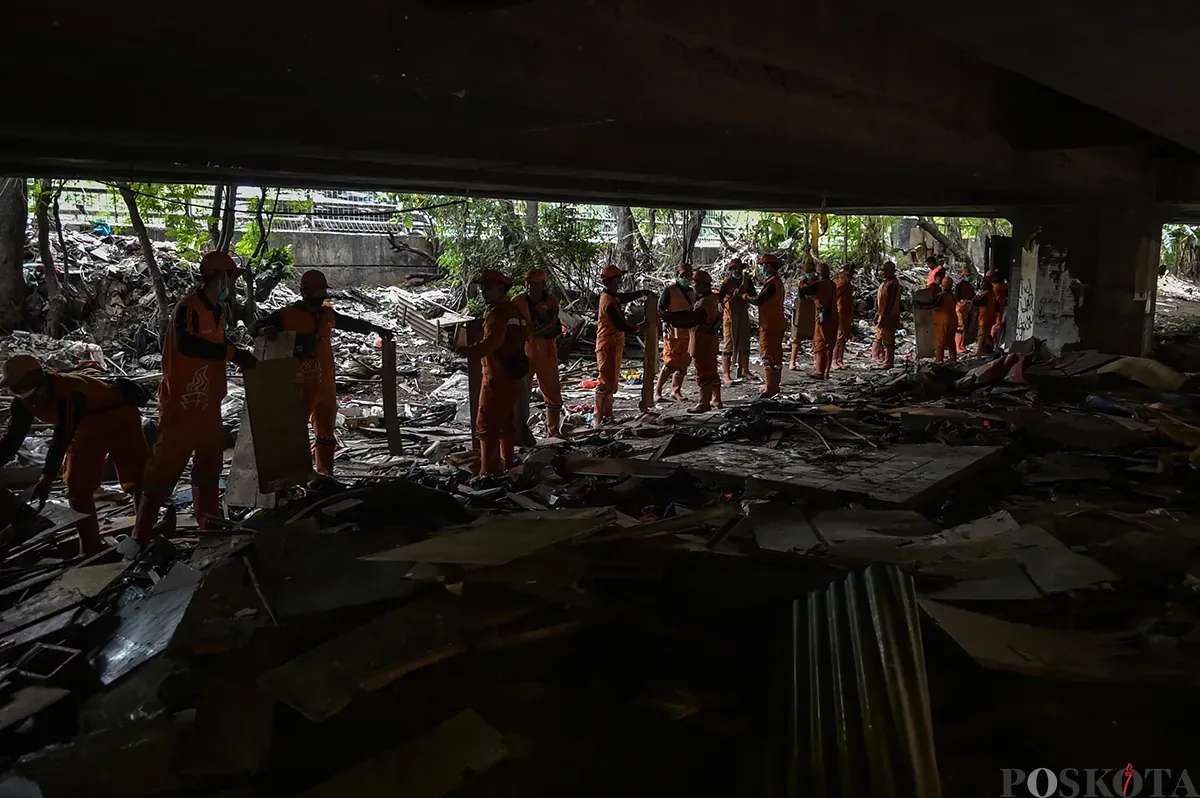 Petugas Suku Dinas Jakarta Barat, membersihkan sisa bangunan rumah bekas tempat tinggal sejumlah warga di bawah Kolong Tol Angke, Grogol Petamburan, Jakarta Barat, Selasa, 7 Januari 2025. (Sumber: Poskoata/ Bilal Nugraha Ginanjar)