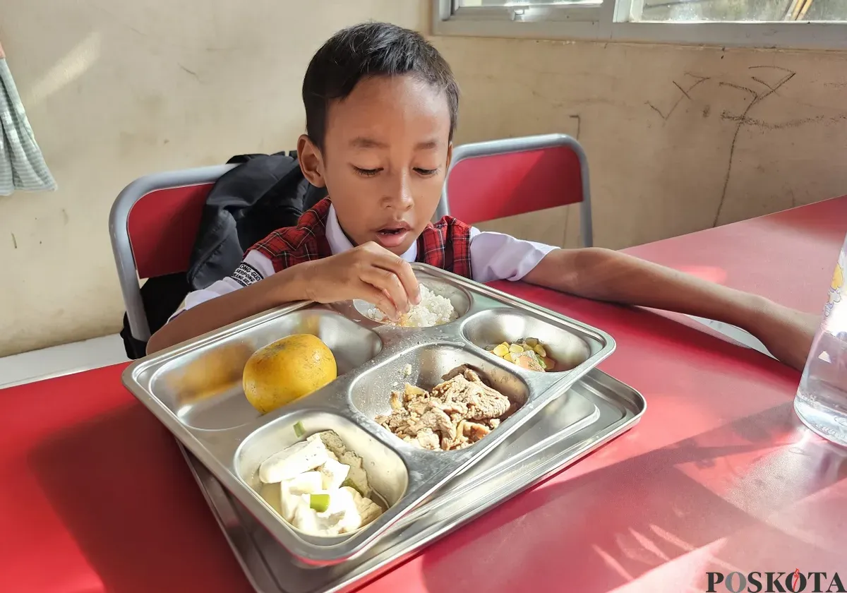 Gibran Hafiz Nurdiansyah, 7 tahun, siswa SDN Lengkong Gudang, Kota Tangsel saat menyantap menu MBG. (Sumber: Poskota/Veronica Prasetio)