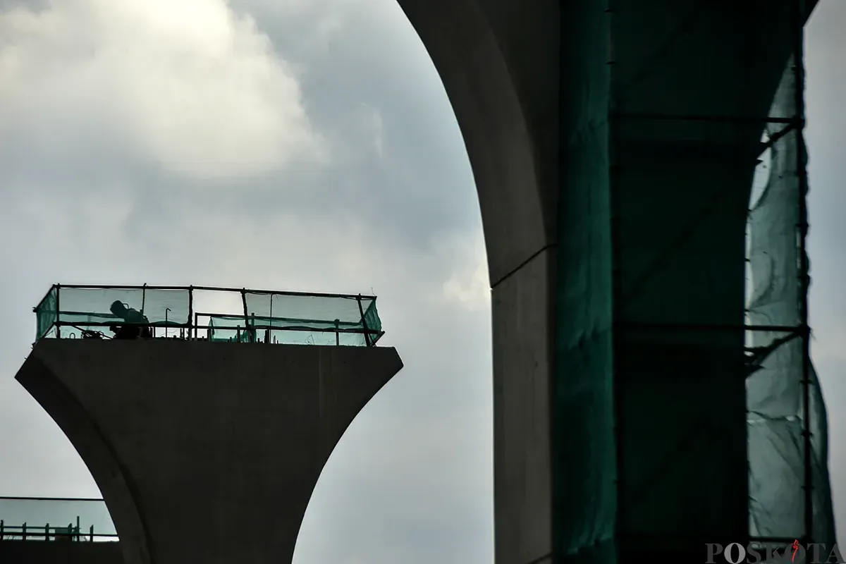 Pekerja menyelesaikan pembangunan stasiun kereta ringan atau Light Rail Transit (LRT) Jakarta fase 1B rute Velodrome-Manggarai di Pramuka, Jakarta Timur, Senin, 13 Januari 2025. (Sumber: Poskota/ Bilal Nugraha Ginanjar)