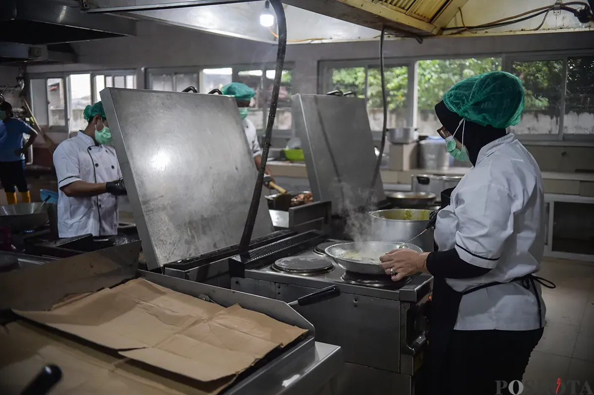 Pekerja menyiapkan paket makanan yang akan didistribusikan pada program Makan Bergizi Gratis (MBG) di Dapur MBG Sekolah Staf dan Komando Angkatan Laut atau (Seskoal) Cipulir, Jakarta Selatan, Selasa, 14 Januari 2025. (Sumber: Poskota/ Bilal Nugraha Ginanjar)