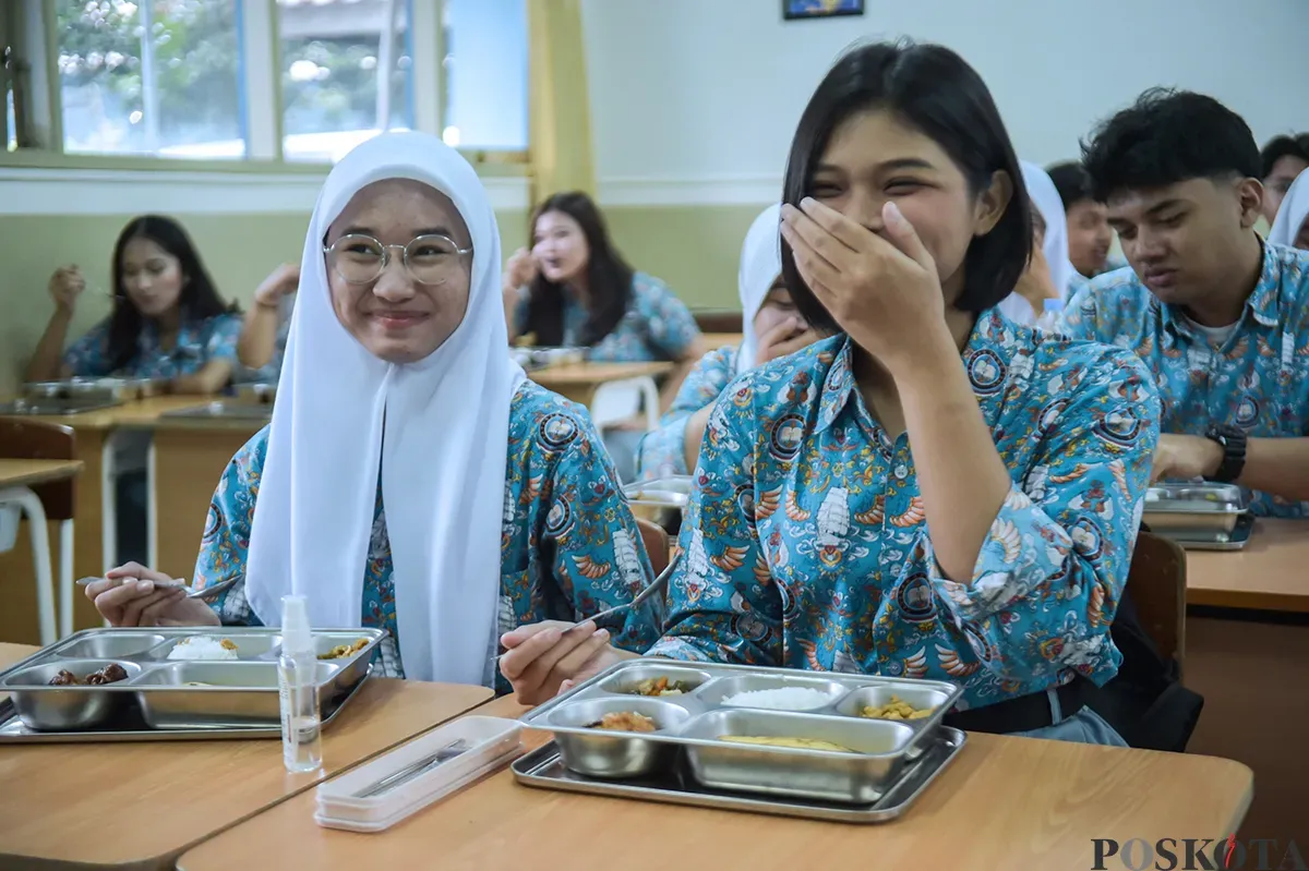 Ilustrasi - Dua orang siswi di salah satu sekolah Jakarta tersenyum sesaat sebelum menyantap Makan Bergizi Gratis yang diberikan. (Sumber: Poskota/ Bilal Nugraha Ginanjar)