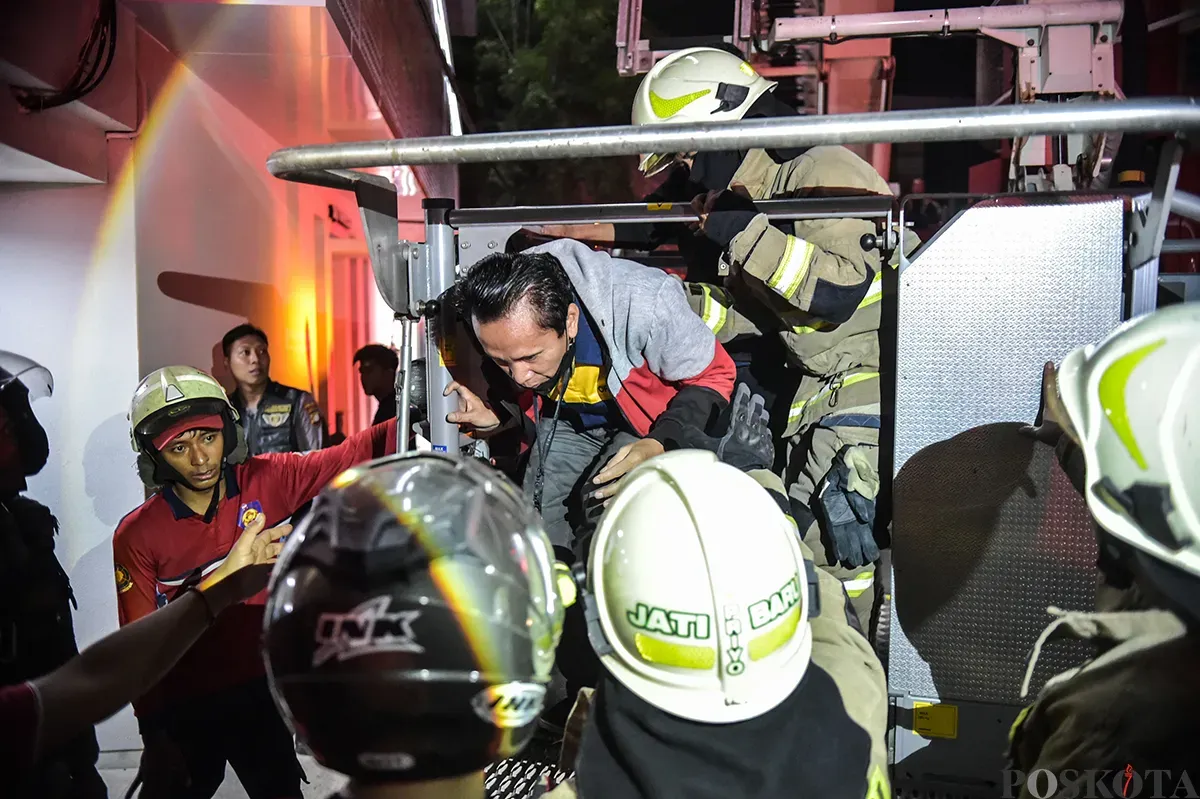 Sejumlah petugas pemadam kebakaran berupaya memadamkan kobaran api sambil mengevakuasi warga yang terjebak dari musibah kebakaran di Glodok Plaza, Tamansari, Jakarta Barat, Rabu 15 Januari 2025. (Sumber: Poskota/Bilal Nugraha Ginanjar)