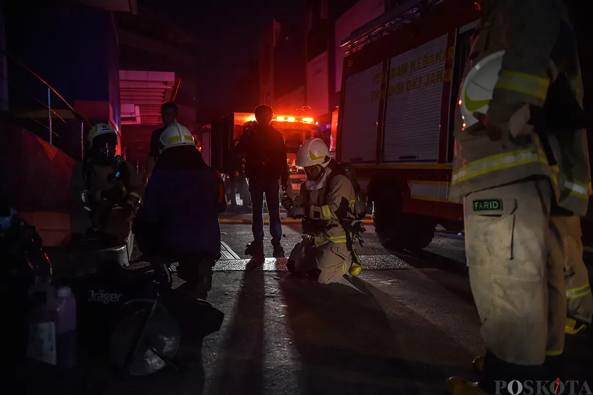 Sejumlah petugas pemadam kebakaran berupaya memadamkan kobaran api sambil mengevakuasi warga yang terjebak dari musibah kebakaran di Glodok Plaza, Tamansari, Jakarta Barat, Rabu 15 Januari 2025. (Sumber: Poskota/Bilal Nugraha Ginanjar)