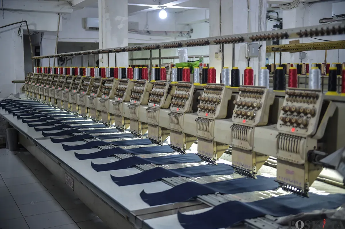 Sejumlah pekerja saat menyelesaikan proses pembuatan celana jeans (jins) yang dibuat dari kain berbahan denim, di sentra pembuatan celana di Kampung Baru, Jakarta Selatan, Rabu, 15 Januari 2025. (Sumber: Poskota/Bilal Nugraha Ginanjar)