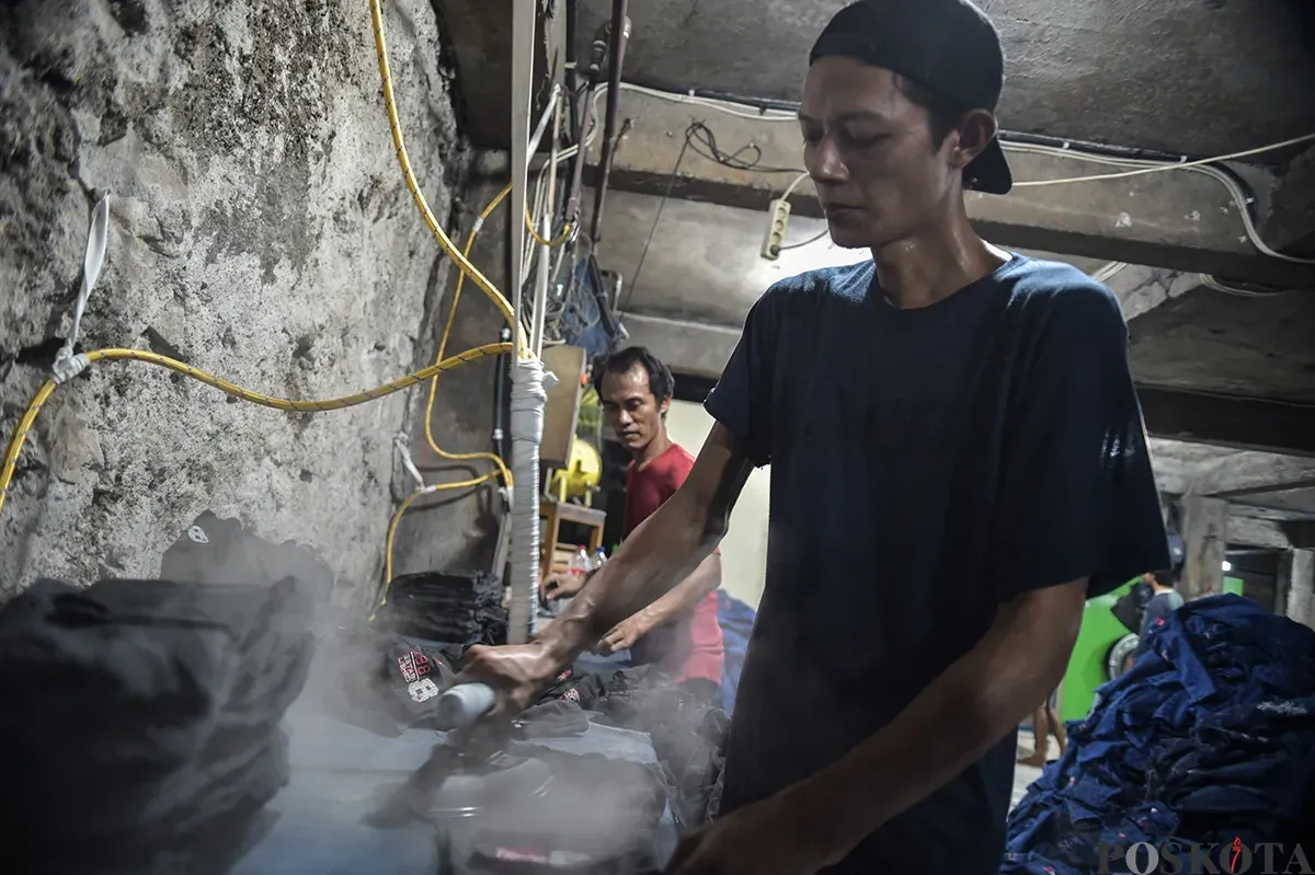 Sejumlah pekerja saat menyelesaikan proses pembuatan celana jeans (jins) yang dibuat dari kain berbahan denim, di sentra pembuatan celana di Kampung Baru, Jakarta Selatan, Rabu, 15 Januari 2025. (Sumber: Poskota/Bilal Nugraha Ginanjar)