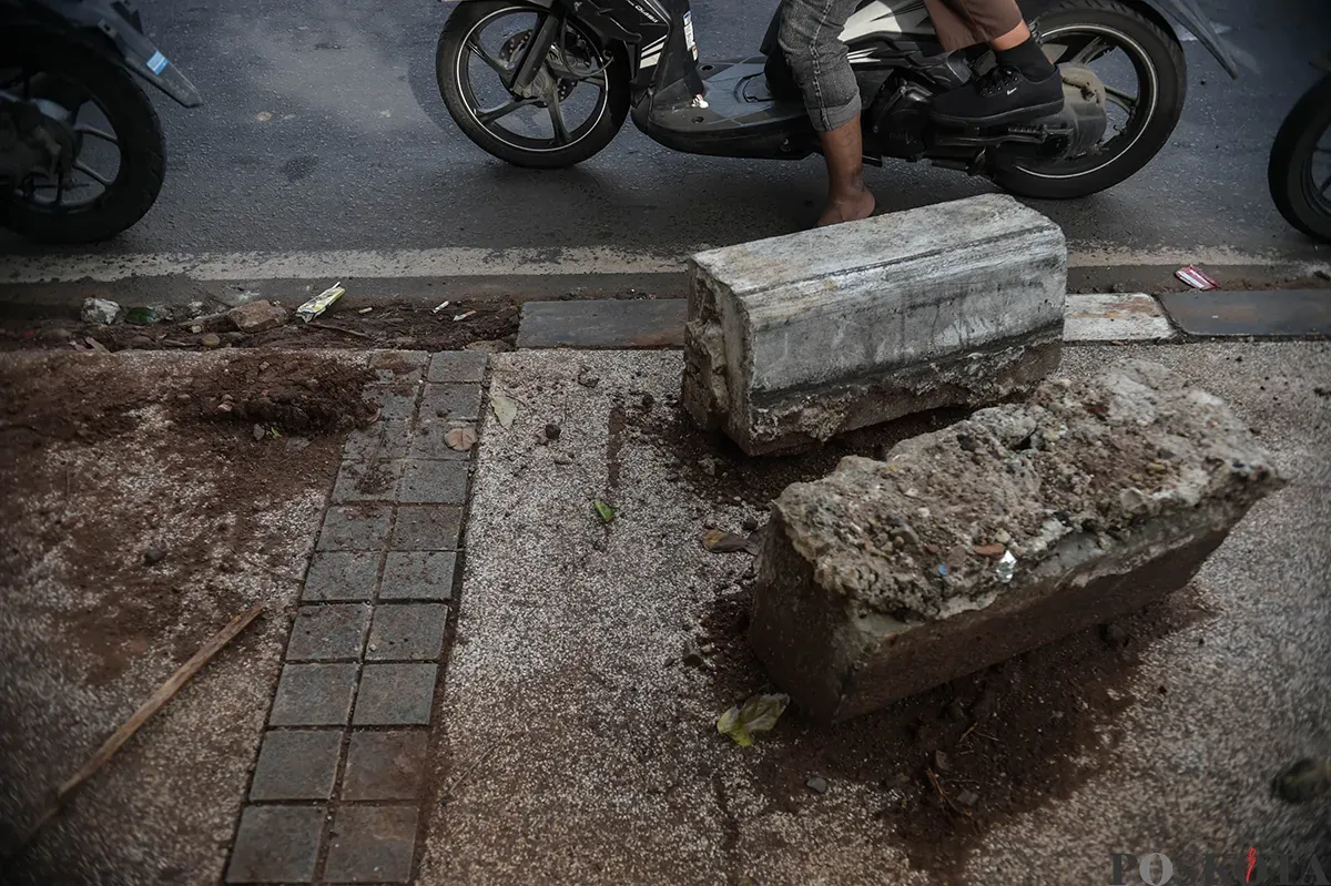 Kondisi trotoar rusak dengan bongkahan beton penyangga yang berserakan tak beraturan dan dibiarkan begitu saja di depan Halte Soleh I, Grogol Selatan, Jakarta Selatan, Rabu, 15 Januari 2025. (Sumber: Poskota/Bilal Nugraha Ginanjar)