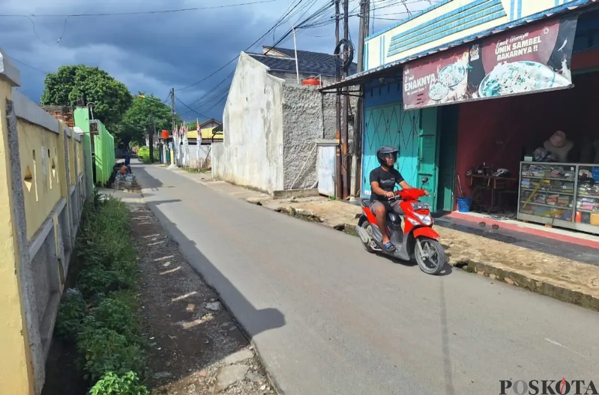 Seorang pengendara motor melintas di lokasi tempat terjadinya aksi begal di Kampung Rawakedaung, Desa Mangunjaya, Kecamatan Tambun Selatan, Sabtu, 18 Januari 2025. (Sumber: Poskota/Ihsan Fahmi)