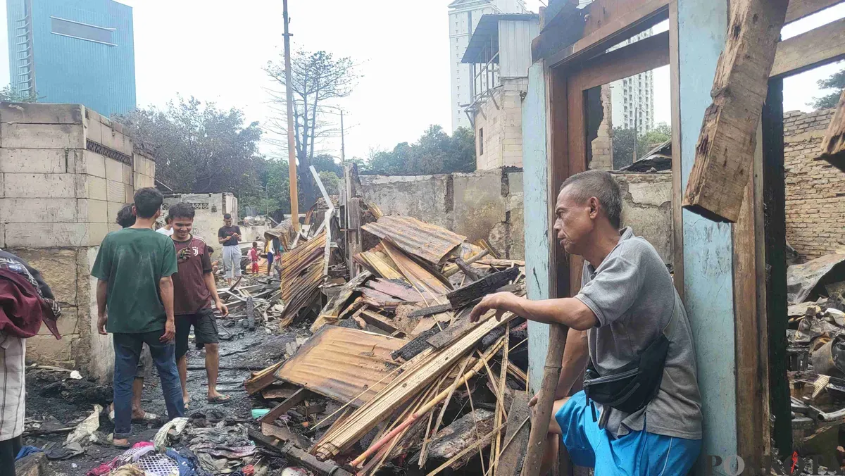 Iyang, 55 tahun, salah satu warga yang rumahnya terdampak kebakaran di Kemayoran, Jakarta Pusat, sedang melihat kondisi terkini rumahnya yang sudah hangus, Selasa 21 Januari 2025. (Sumber: Poskota/Pandi Ramedhan)