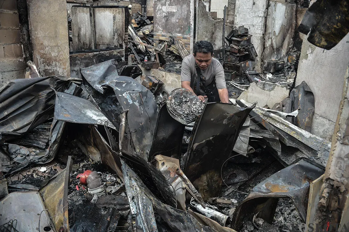 Sejumlah warga menyaksikan proses pendinginan terhadap puing-puing rumah yang terbakar yang dilakukan oleh petugas pemadam kebakaran usai terjadi musibah kebakaran di permukiman padat penduduk di Jalan Kemayoran Gempol, Kemayoran, Jakarta, Selasa, 21 Januari 2025. (Sumber: Poskota/ Bilal Nugraha Ginanjar)