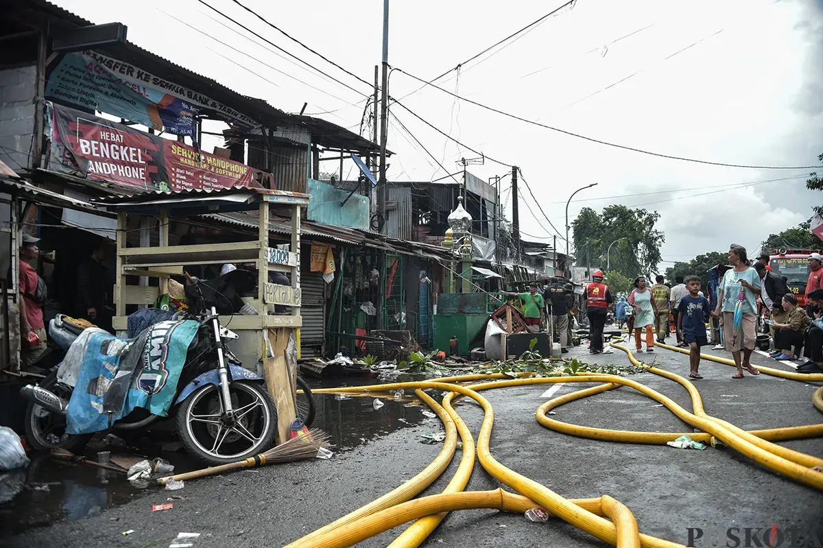 Sejumlah warga menyaksikan proses pendinginan terhadap puing-puing rumah yang terbakar yang dilakukan oleh petugas pemadam kebakaran usai terjadi musibah kebakaran di permukiman padat penduduk di Jalan Kemayoran Gempol, Kemayoran, Jakarta, Selasa, 21 Januari 2025. (Sumber: Poskota/ Bilal Nugraha Ginanjar)