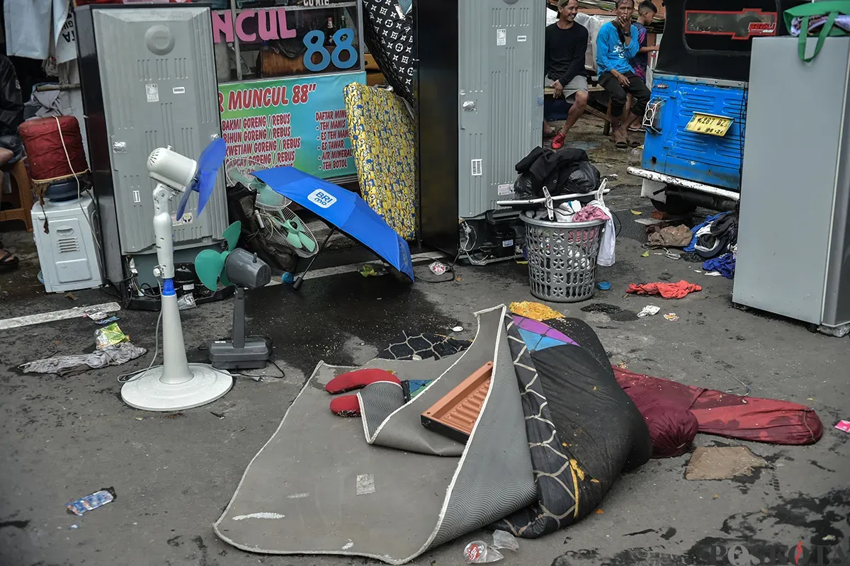 Sejumlah warga menyaksikan proses pendinginan terhadap puing-puing rumah yang terbakar yang dilakukan oleh petugas pemadam kebakaran usai terjadi musibah kebakaran di permukiman padat penduduk di Jalan Kemayoran Gempol, Kemayoran, Jakarta, Selasa, 21 Januari 2025. (Sumber: Poskota/ Bilal Nugraha Ginanjar)