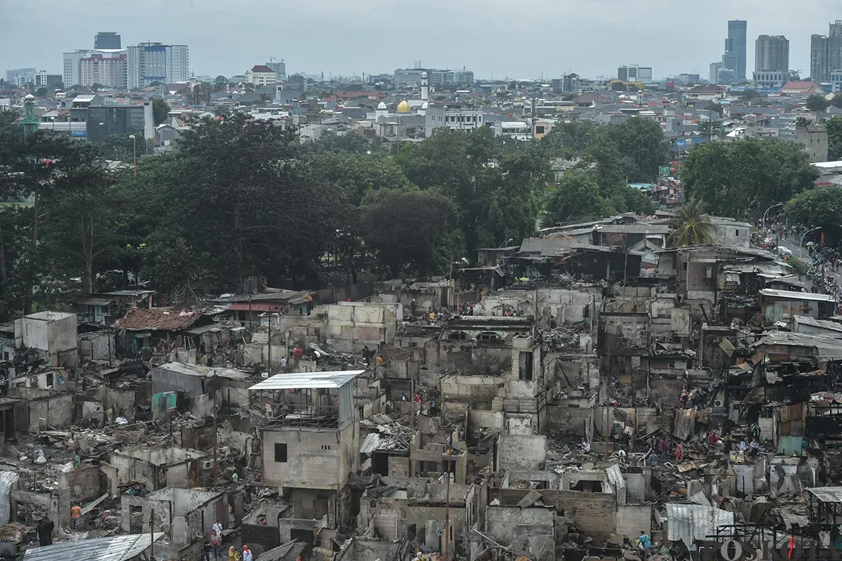 Sejumlah warga menyaksikan proses pendinginan terhadap puing-puing rumah yang terbakar yang dilakukan oleh petugas pemadam kebakaran usai terjadi musibah kebakaran di permukiman padat penduduk di Jalan Kemayoran Gempol, Kemayoran, Jakarta, Selasa, 21 Januari 2025. (Sumber: Poskota/ Bilal Nugraha Ginanjar)