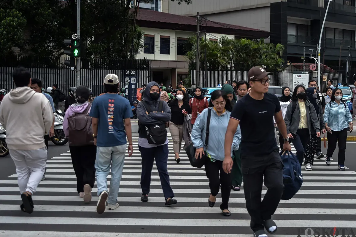 Para pekerja berjalan melintasi pedestrian saat jam pulang kerja di kawasan Jalan Jenderal Sudirman, Jakarta, Rabu, 22 Januari 2025. (Sumber: Poskota/ Bilal Nugraha Ginanjar)