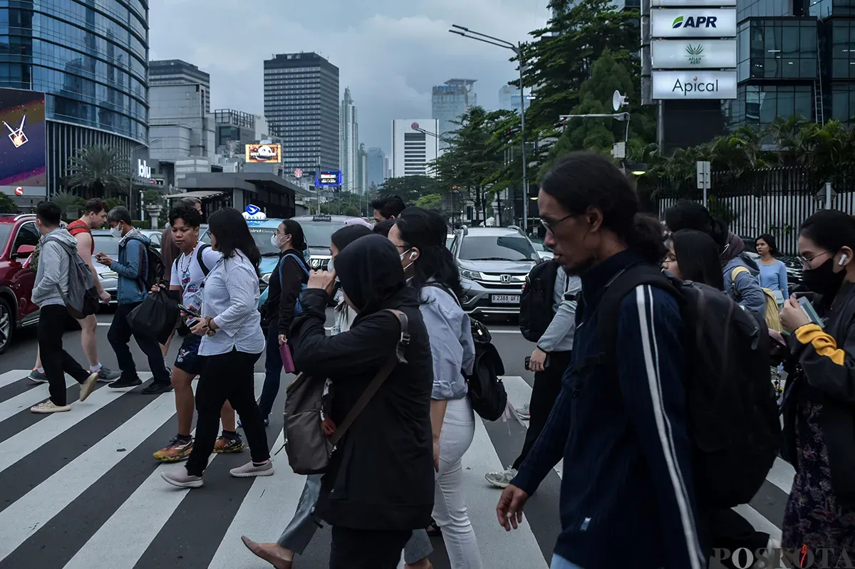 Para pekerja berjalan melintasi pedestrian saat jam pulang kerja di kawasan Jalan Jenderal Sudirman, Jakarta, Rabu, 22 Januari 2025. (Sumber: Poskota/ Bilal Nugraha Ginanjar)